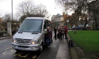 Femma stapt als laatste uit de minibus (voor de foto).