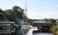 Een fraai zeilschip komt door de brug over het Caledonisch kanaal, op weg van de Ierse zee naar de Noordzee.