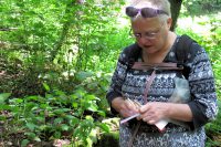 Femma zet onze namen in het logboek van de geocache.