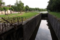 Het oude, in onbruik geraakte schutsluisje in het kanaal d'Orléans. Op de achtergrond de camperplaats.