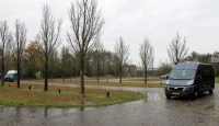 Op de parkeerplaats in Hindeloopen. De auto's elk aan een uiteinde van het straatje, het mastje is zichtbaar, links van de eerste boom. 
