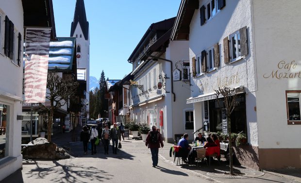 Femma passeert een groepje op een terras. Ze zittten gezellig in hun t-shirtjes op het terras, aan de pizza met een groot glas bier.