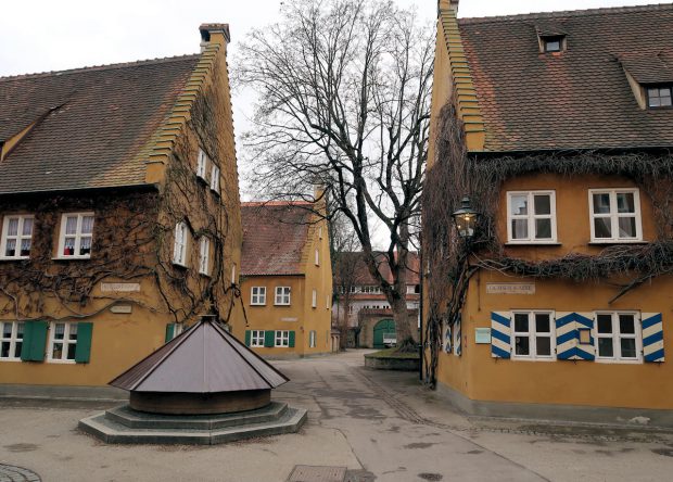 Een doorkijkje in de ommuurde wijk 'Fuggerei', de oudste nog werkende vorm van sociale woningbouw ter wereld.