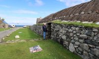 Femma voor de ingang van het 'blackhouse'.