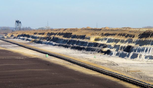 De grond wordt laag voor laag afgegraven en afgevoerd door de enorme machine in de verte. Op de volgende foto de machine gezien van de andere kant...