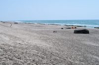 Het strand links, met hier en daar een van het duin gerolde Duitse bunker...