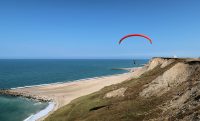 Een prachtig gezicht op zee en de paragliders.