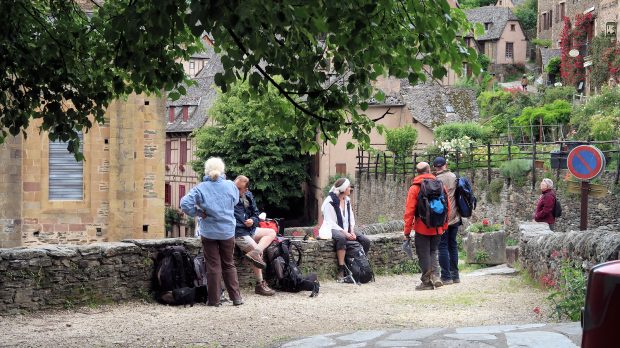 In Conques zien we veel wandelaars met rugzak.