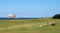 Golfbaan met vreemd eilandje op de achtergrond.