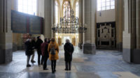 Het vrij lege interieur van de Walburgiskerk. De kroonluchter met 12 kaarsen is van 1395.