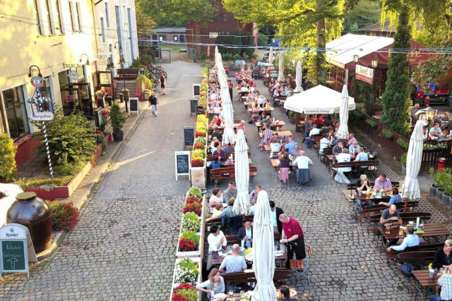 (Foto DampfE) Het terras, links het restaurant, wij staan met de camper links achterin, op een binnenpleintje.