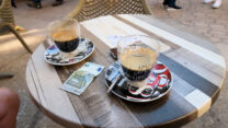 Un café allongé of un américain: espresso aangelengd (= allongé) met heet water. Deze koffie lijkt qua sterkte het meeste op een ‘gewoon’ Hollands kopje koffie. Kost in principe hetzelfde als een espresso en is daarmee de goedkoopste koffie op de kaart.