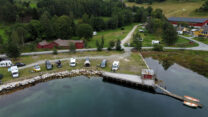 Het front van de camping, gezien vanaf het fjord. Wij staan tweede van rechts.